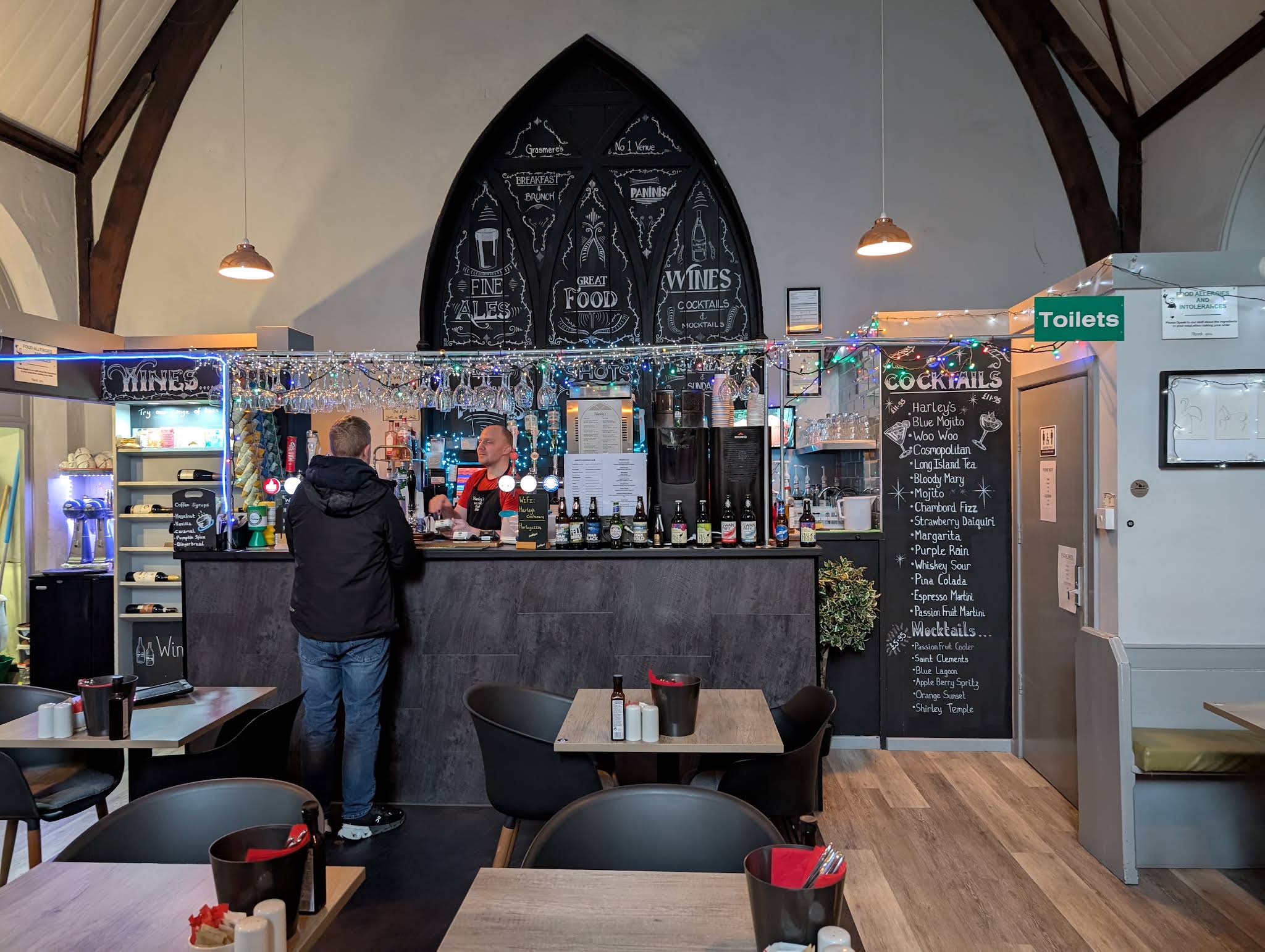 Harley’s bar with timber beams, an arched chalkboard, pendant lights and tables